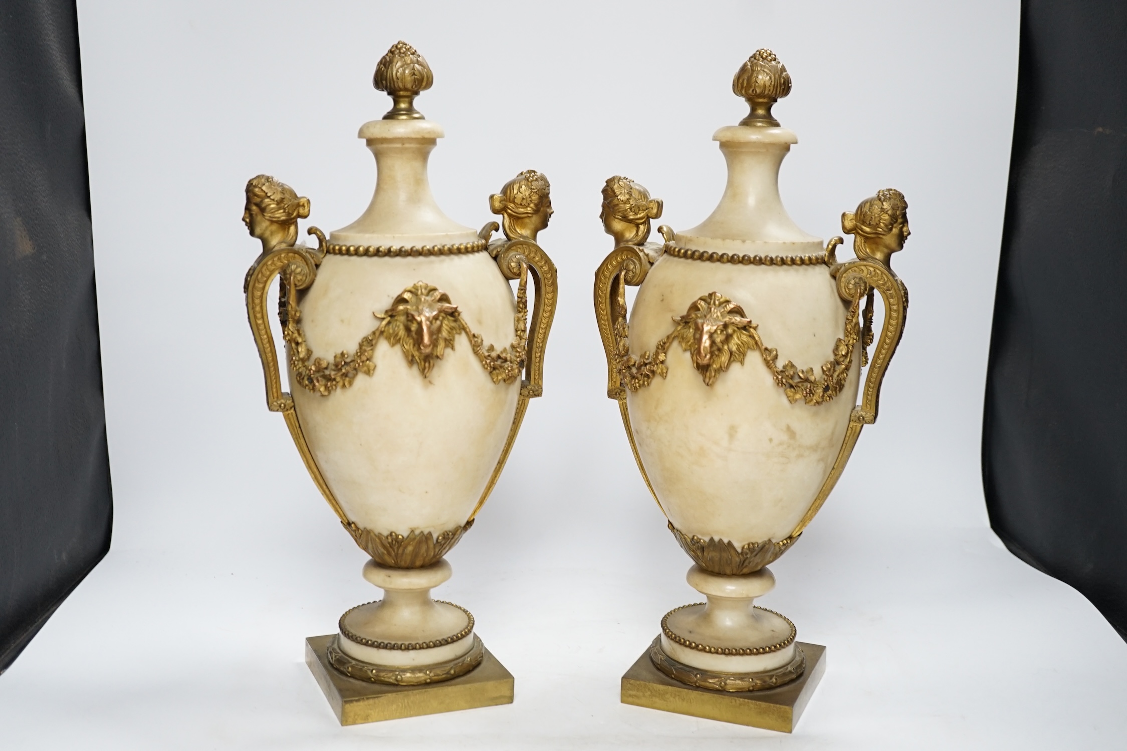 A pair of Adam style gilt metal mounted alabaster urns, 42cm high